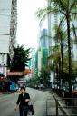 Chinese woman walks between towering blocks of living accommodation in Hong Kong