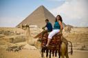 Reel Life Photos wedding photographer Elaine on camel by pyramids in Egypt