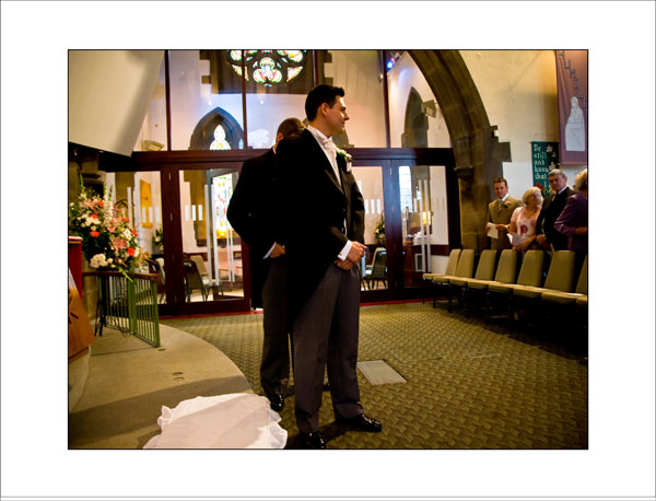 groom watches his bride walk down the aisle