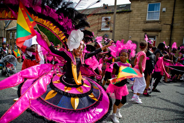 children dancing in Caribbean carnival costumes during the parade through Huddersfield city centre