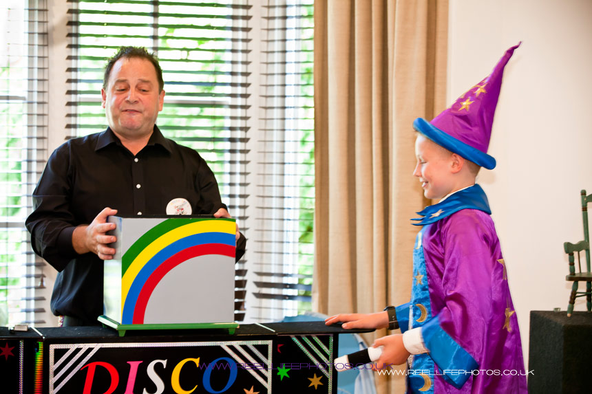 Magician with his new little apprentice at wedding magic show