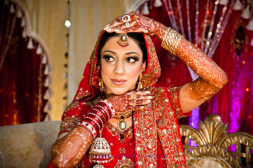 Asian wedding photography with bride posing her hennaed hands