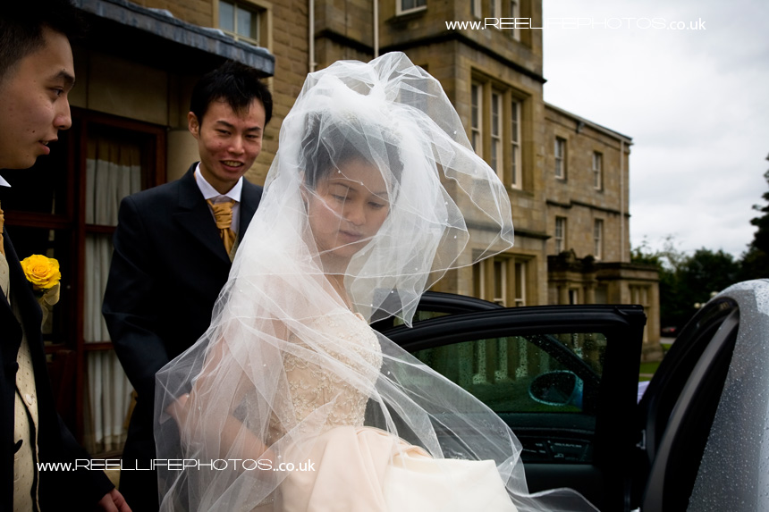 bride and groom leaving Weetwood Hall after their wedding ceremony