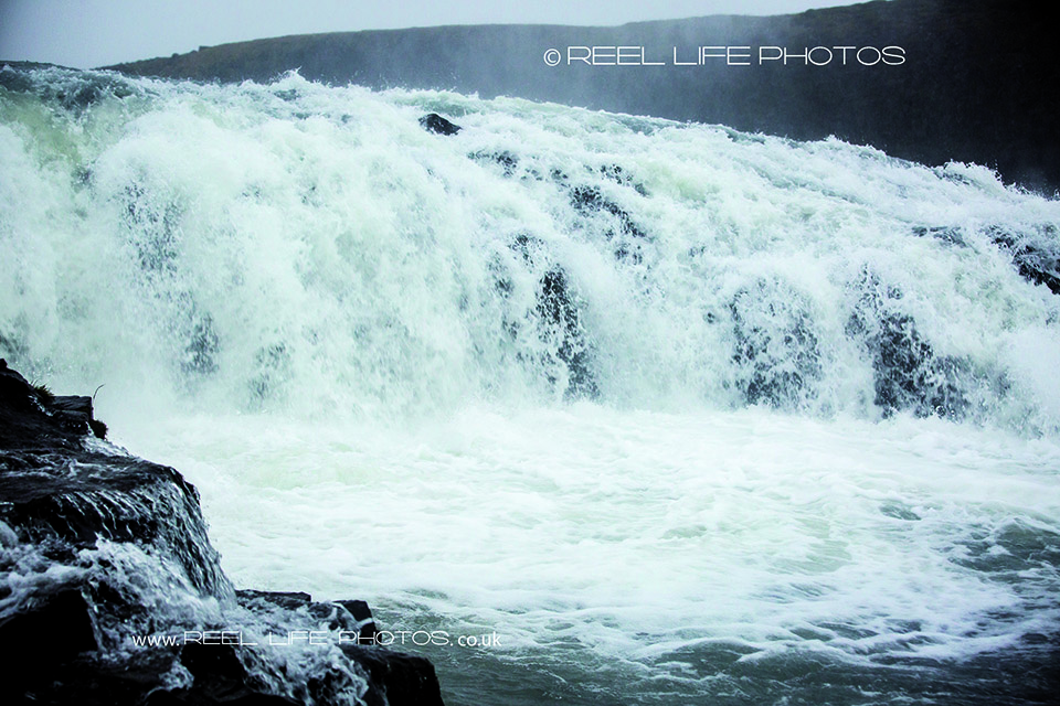 Reprtage rather than posed engagement photos in Iceland on a rainy October day at Selfoss waterfall.