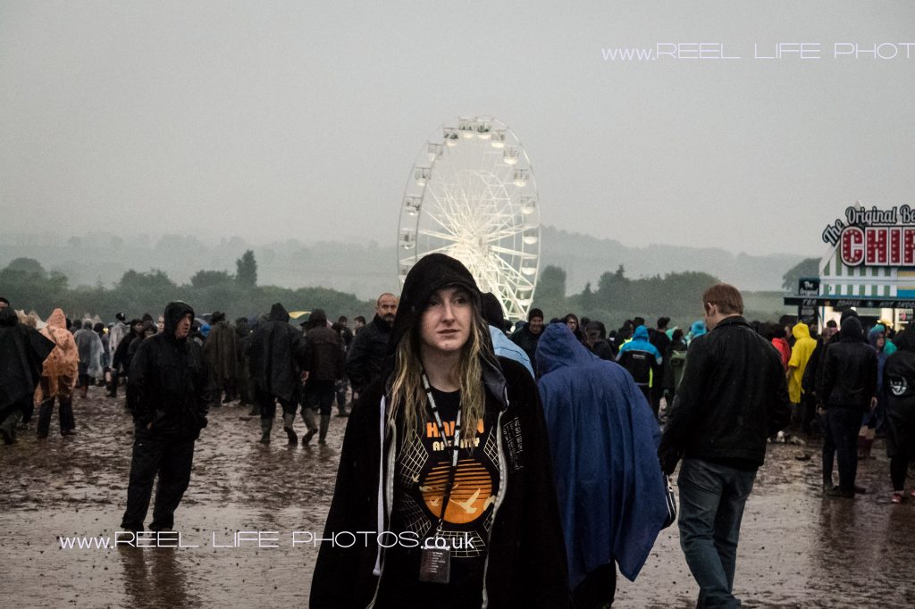 Download 2016 illuminated Ferris wheel as dusk falls and dismal-faced girl with long bedraggled hair. 