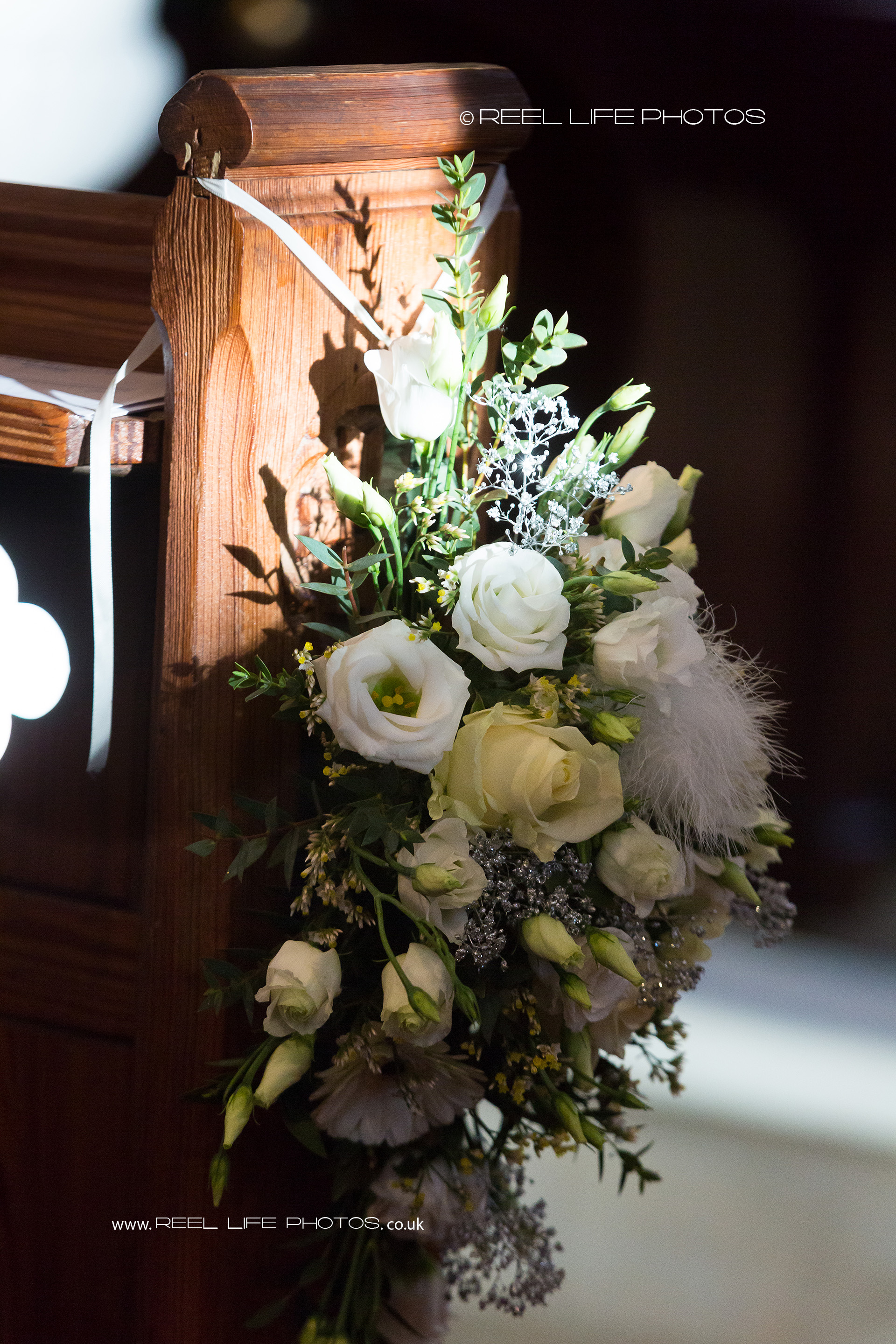 Beautiful floral arrangements decorate the sides of the church pews