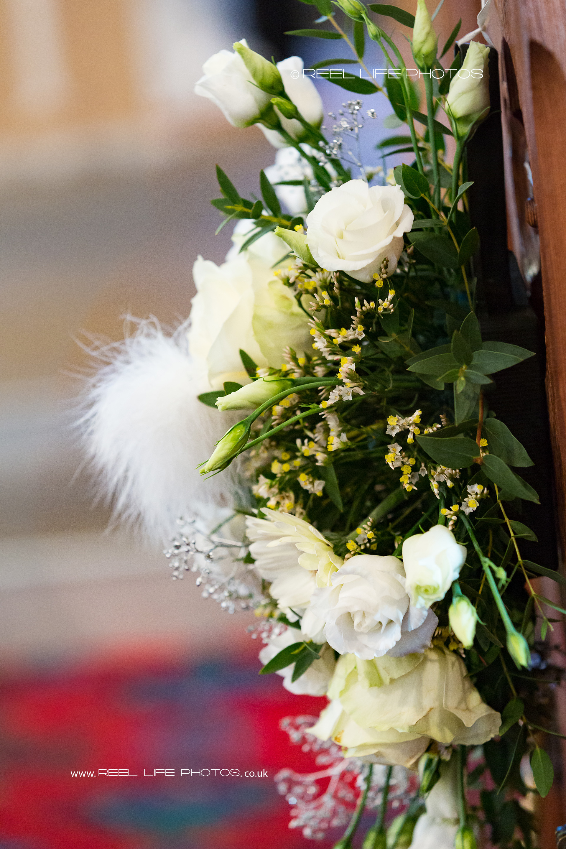 Beautiful floral arrangements decorate the sides of the church pews