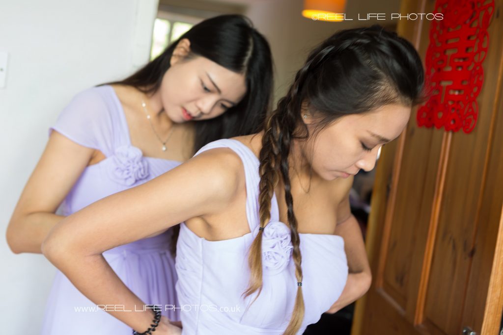 Two of the Chinese bridemaids.Chinese bridesmaids help each other into their lilac dresses.