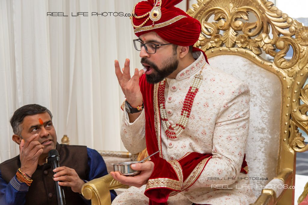 Indian groom tasting sugar during his wedding ceremony